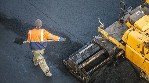 asphalt technician with a shovel